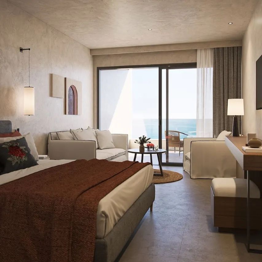 Modern eingerichtetes Hotelzimmer mit Doppelbett, Sofa und Balkon mit Blick auf das Meer.