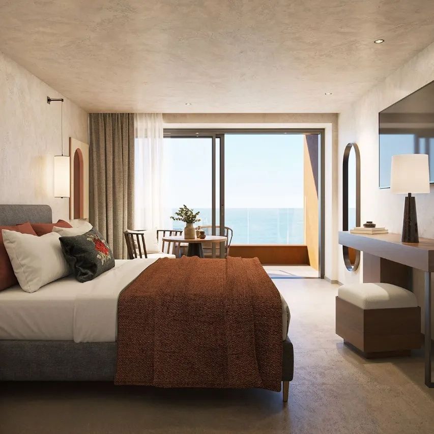 Modernes Hotelzimmer mit Doppelbett, Sitzbereich und gläserner Balkontür mit Meerblick.