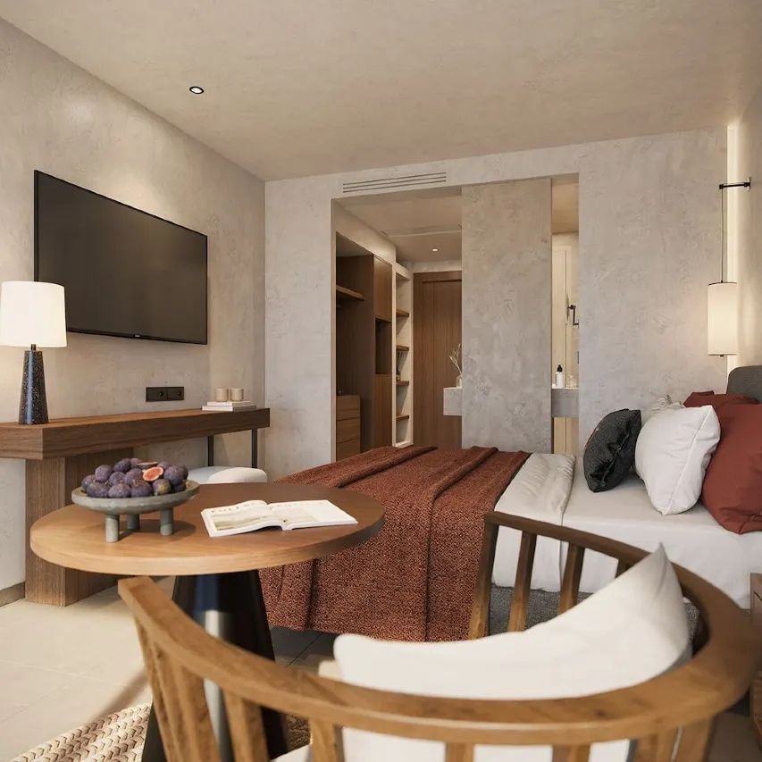 Moderner Wohnbereich im Hotelzimmer mit Holztisch, Stühlen, Fernseher und Doppelbett.