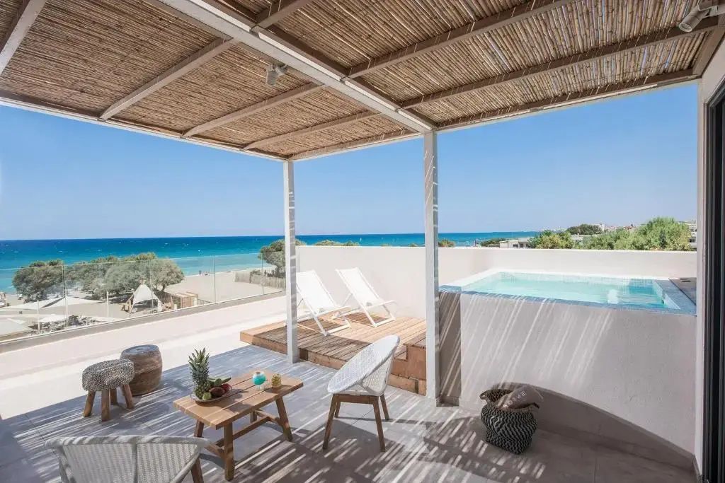 Überdachte Terrasse mit Sitzmöglichkeiten, kleinem Pool und direktem Blick auf das Meer.