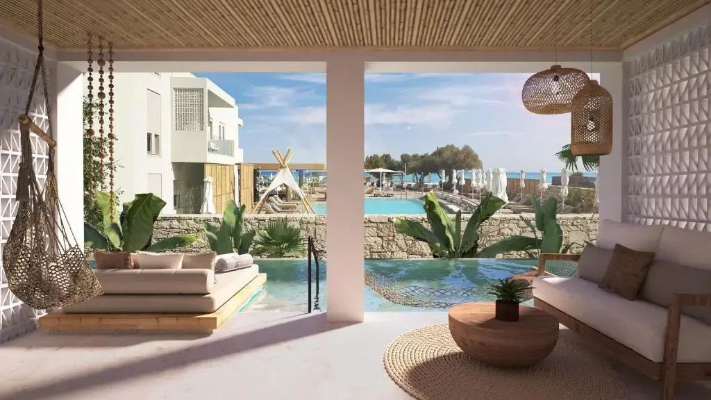 Blick von einer überdachten Terrasse mit kleinem Pool auf die Hotelanlage und das Meer.