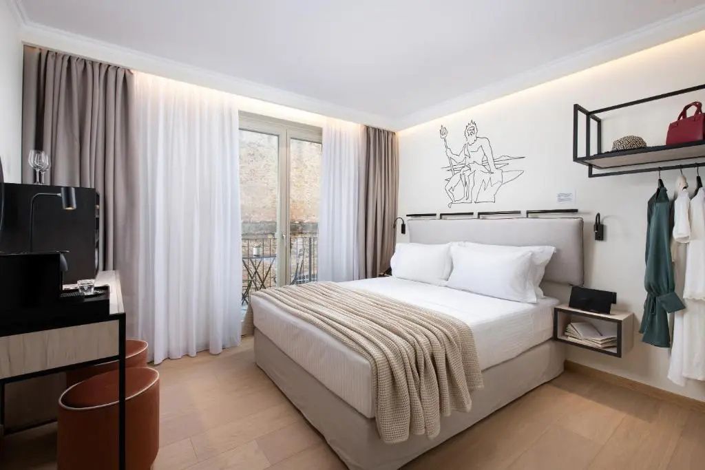 Geräumiges Schlafzimmer mit Doppelbett, hellen Vorhängen und Balkontür.