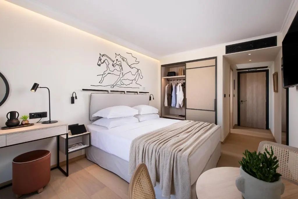 Hell eingerichtetes Schlafzimmer mit Doppelbett, Wandzeichnung von Pferden und Kleiderschrank.
