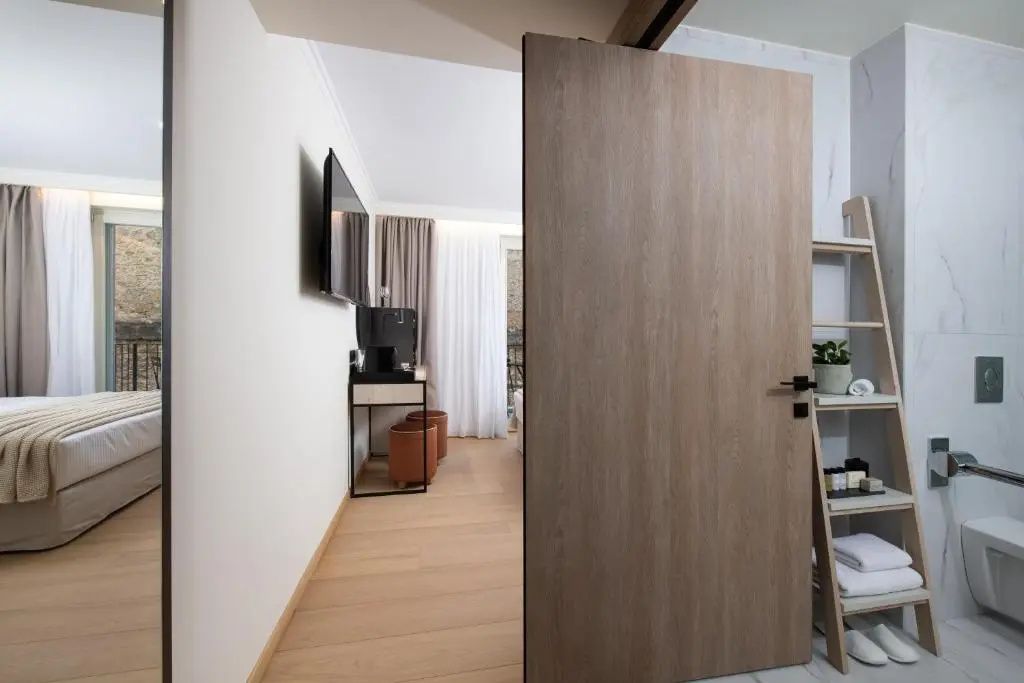 Blick durch eine geöffnete Schiebetür aus Holz in das modern eingerichtete Zimmer.