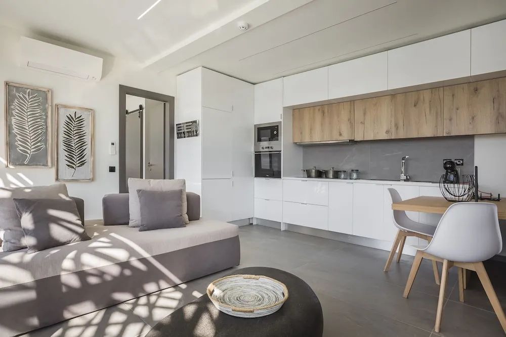Moderne Einbauküche und Wohnbereich mit Sofa, Couchtisch und hellem Boden.