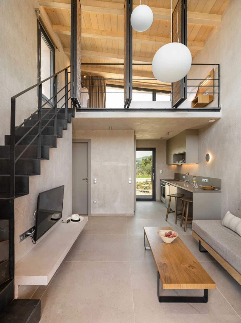 Offener Maisonette-Wohnbereich mit Metalltreppe, Sofa und Blick auf die obere Empore.