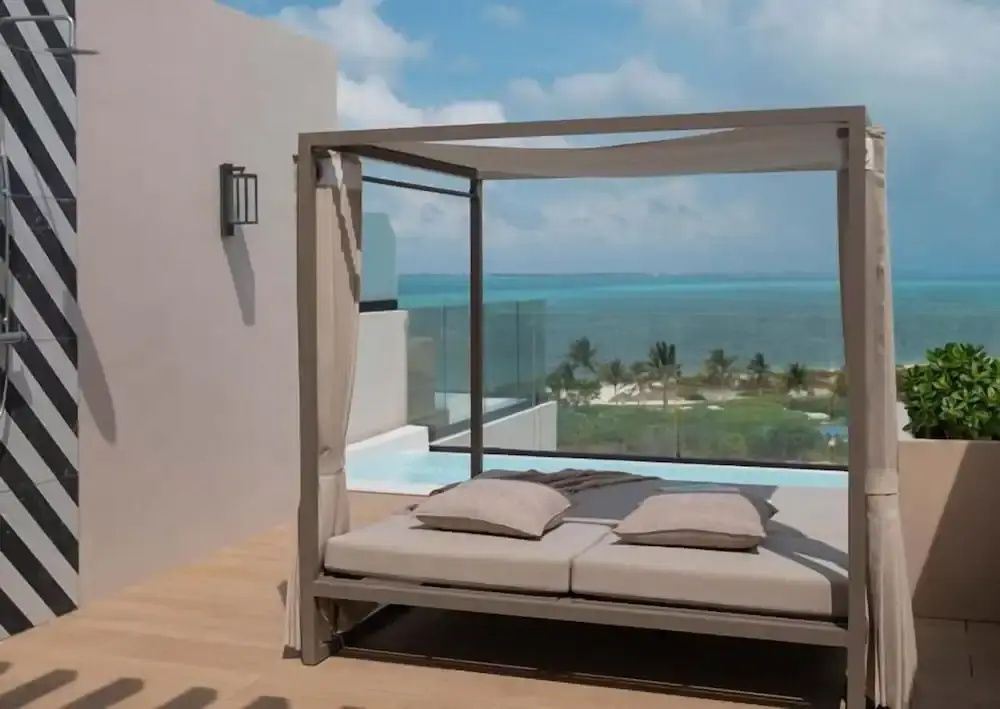 Dachterrasse mit einem überdachten Tagesbett, einem kleinen Pool und Blick auf das Meer.