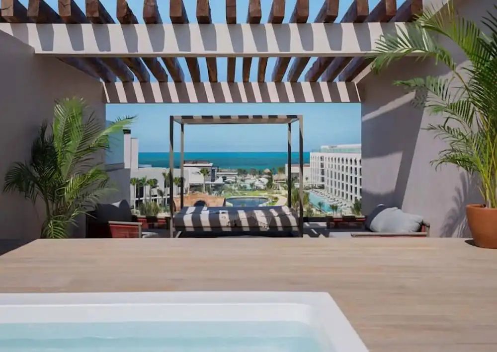 Überdachte Dachterrasse mit Himmelbett und Meerblick über die Hotelanlage.