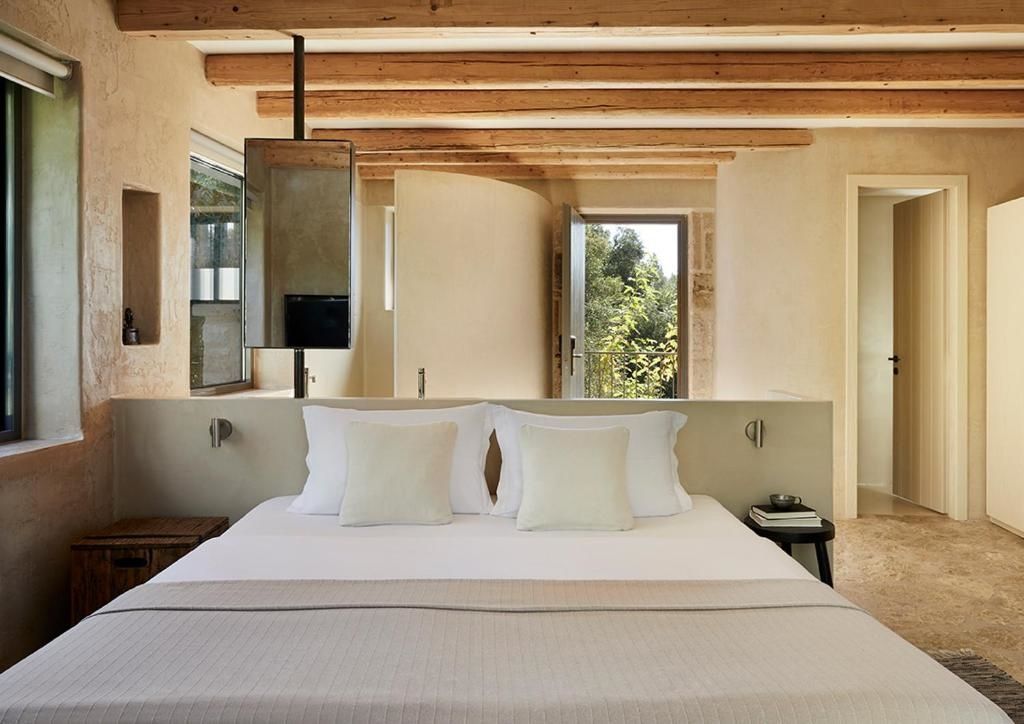 Helles Schlafzimmer mit Doppelbett, Holzdecke und sanften Naturtönen.