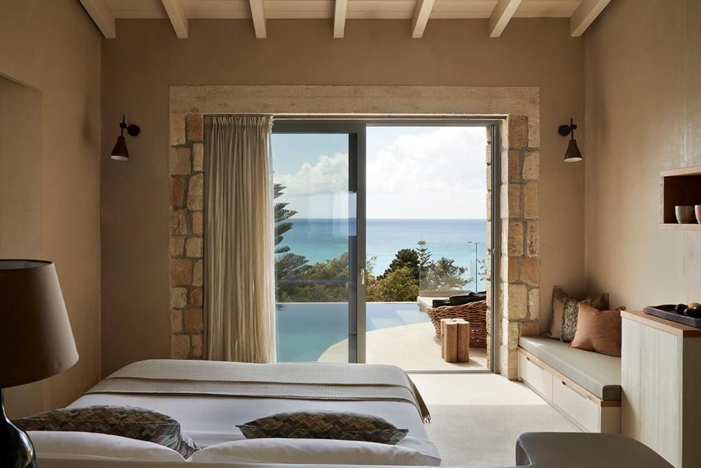 Blick aus dem Schlafzimmer über die Terrasse mit Pool auf das blaue Meer.