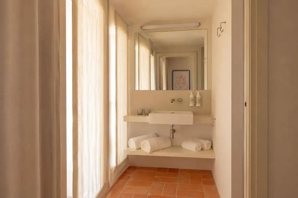 Waschtisch mit weißem Waschbecken, Spiegel und Handtüchern im Badezimmer