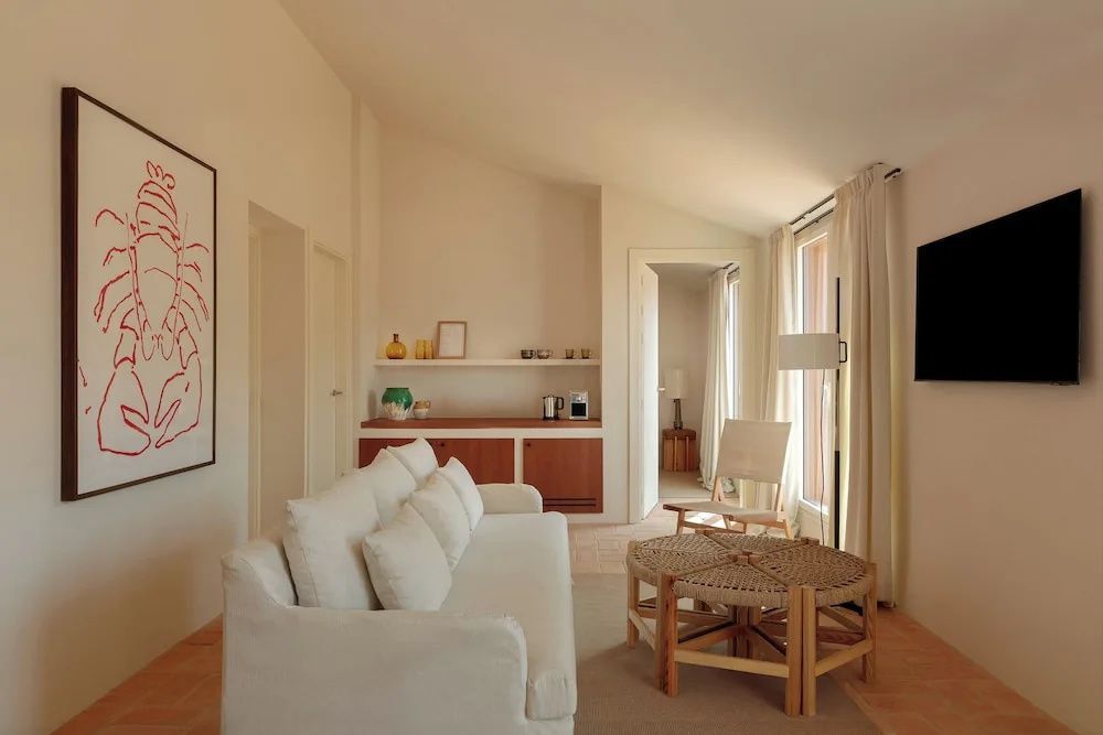 Heller Wohnbereich einer Suite mit weißem Sofa und Holz-Couchtisch.