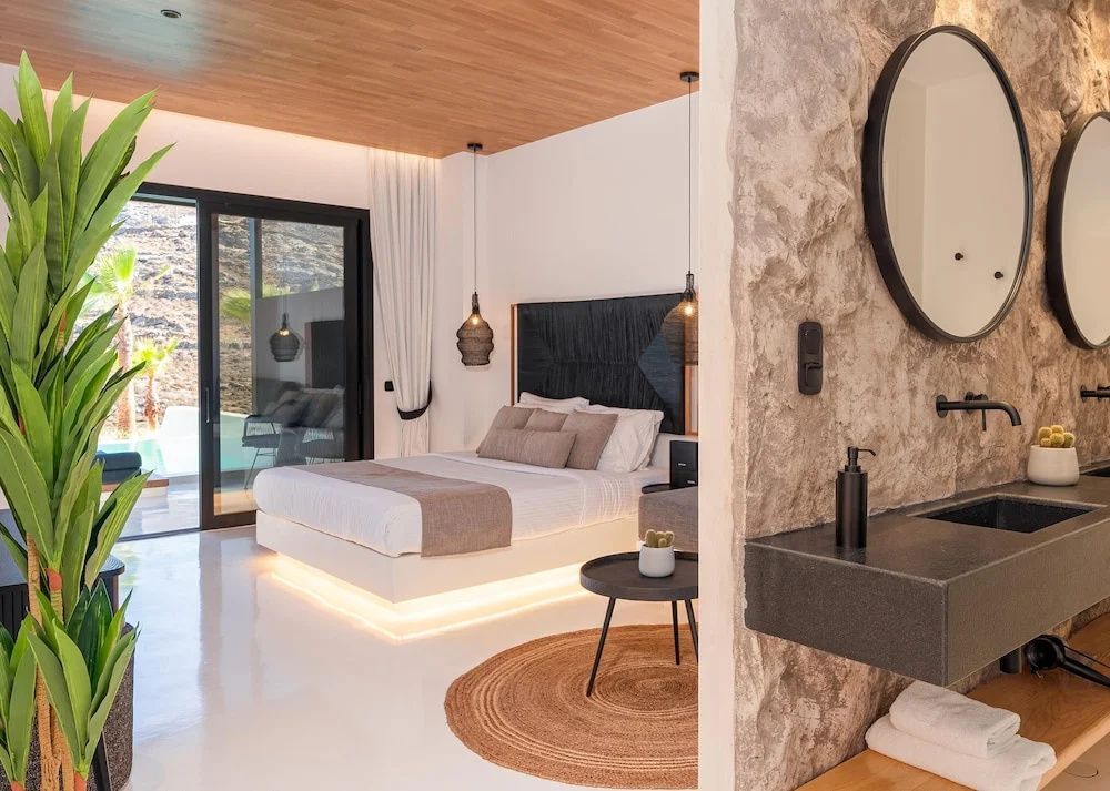 Helles Schlafzimmer mit Doppelbett, Holzdecke und direktem Zugang zur Terrasse.