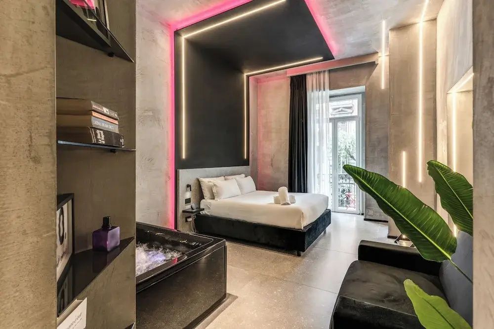 Geräumiges Zimmer mit großem Doppelbett, integriertem Whirlpool und Balkonzugang.