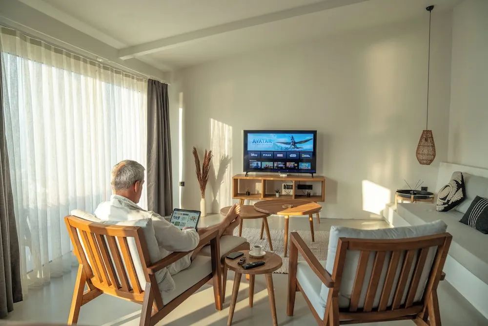 Wohnzimmer einer Suite mit Fernseher, Couchtisch und Sesseln.