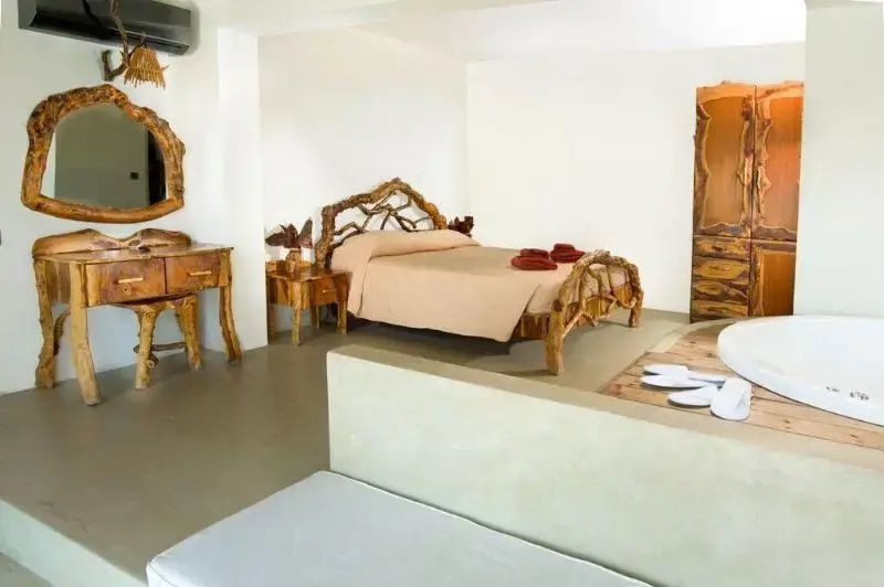 Schlafzimmer mit einem Doppelbett aus rustikalem Holz und passendem Schminktisch.