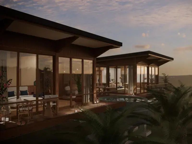 Holzvillen des Resorts mit großzügigen Glasfronten und Terrasse bei Dämmerung.