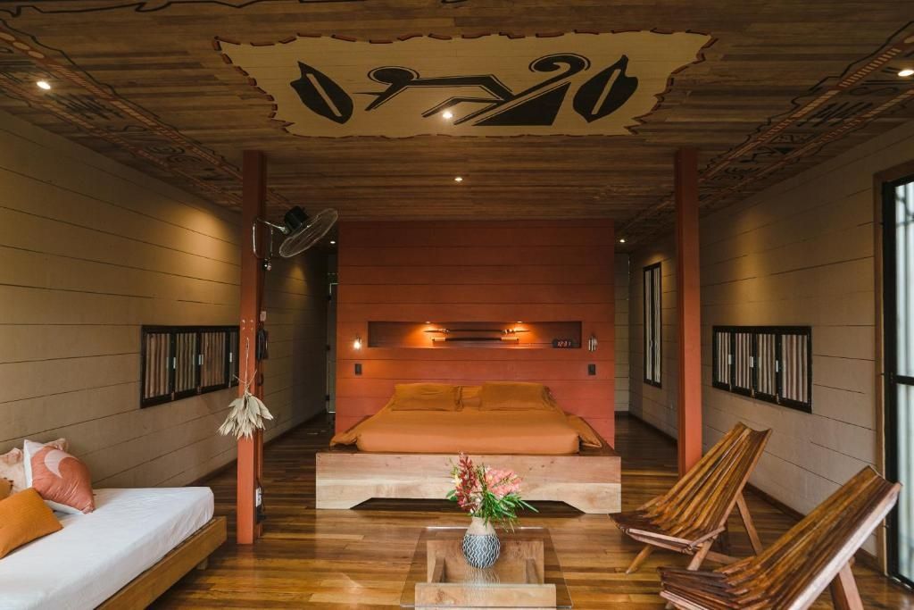 Geräumiges Schlafzimmer aus Holz mit einem Doppelbett und kunstvoller Deckenverzierung.