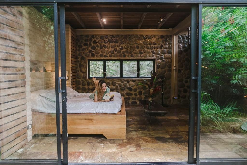 Schlafzimmer mit einer Wand aus Natursteinen und einem großzügigen Doppelbett.