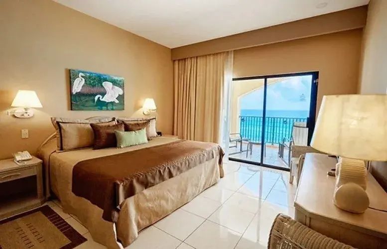 Schlafbereich mit Doppelbett und Schiebetür zum Balkon mit Blick auf das Meer.