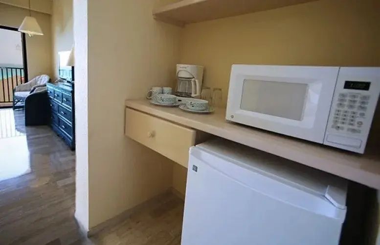 Kleine Küchenzeile im Zimmer mit Mikrowelle, Kaffeemaschine und Minibar.