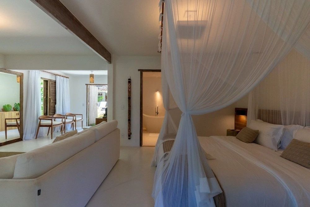 Geräumige Suite mit Schlafbereich, Sofa und Blick ins Badezimmer