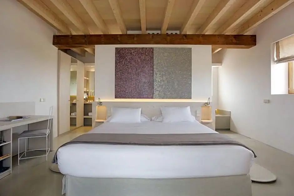 Schlafzimmer mit Holzbalkendecke, Wandbild und weißem Doppelbett