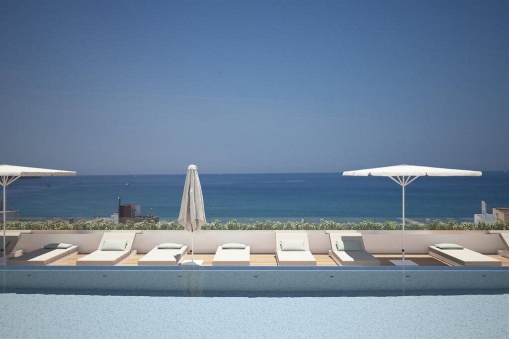 Pool mit Liegen und Meerblick im Hotel HM Ayron Park – Adults Only