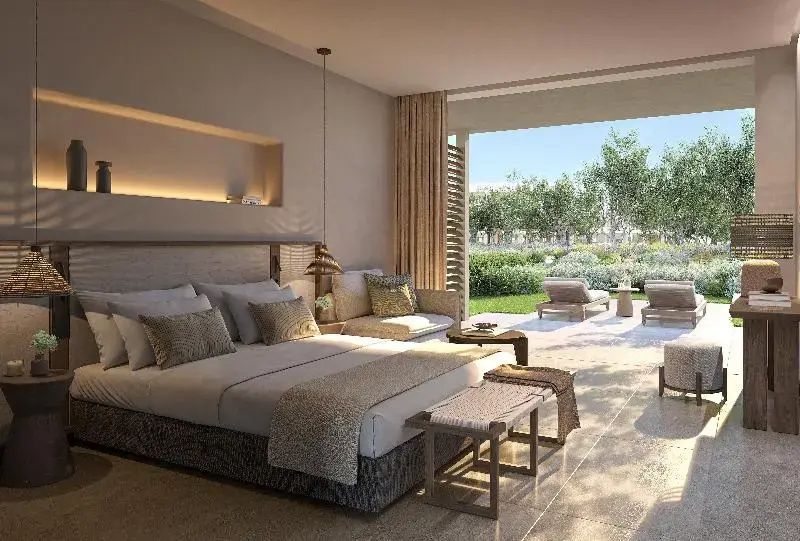 Geräumiges Schlafzimmer mit Doppelbett, Sitzbereich und Schiebetür zur Terrasse im Garten.