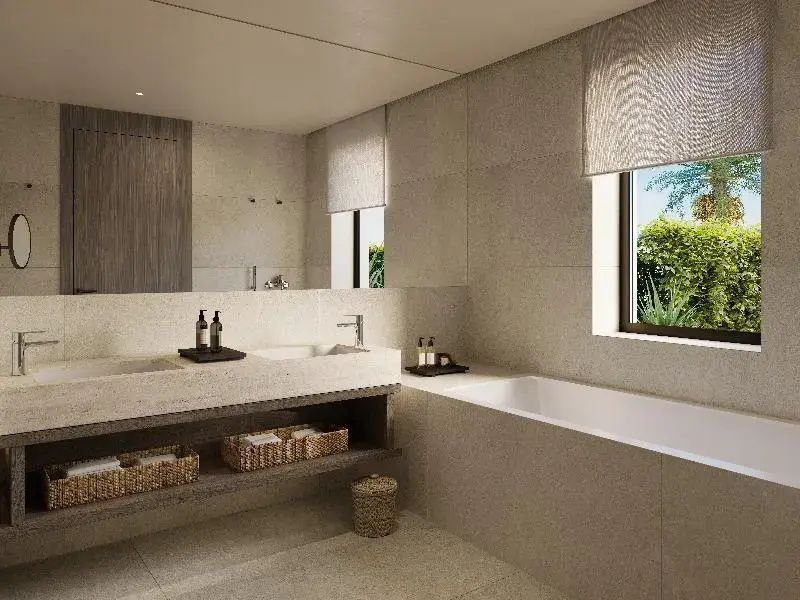 Modernes Badezimmer in beigen Farbtönen mit Steinwaschbecken, Spiegel und Badewanne.