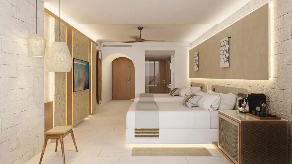 Helles Hotelzimmer mit zwei Betten, Fernseher an der Wand und Holzmöbeln.