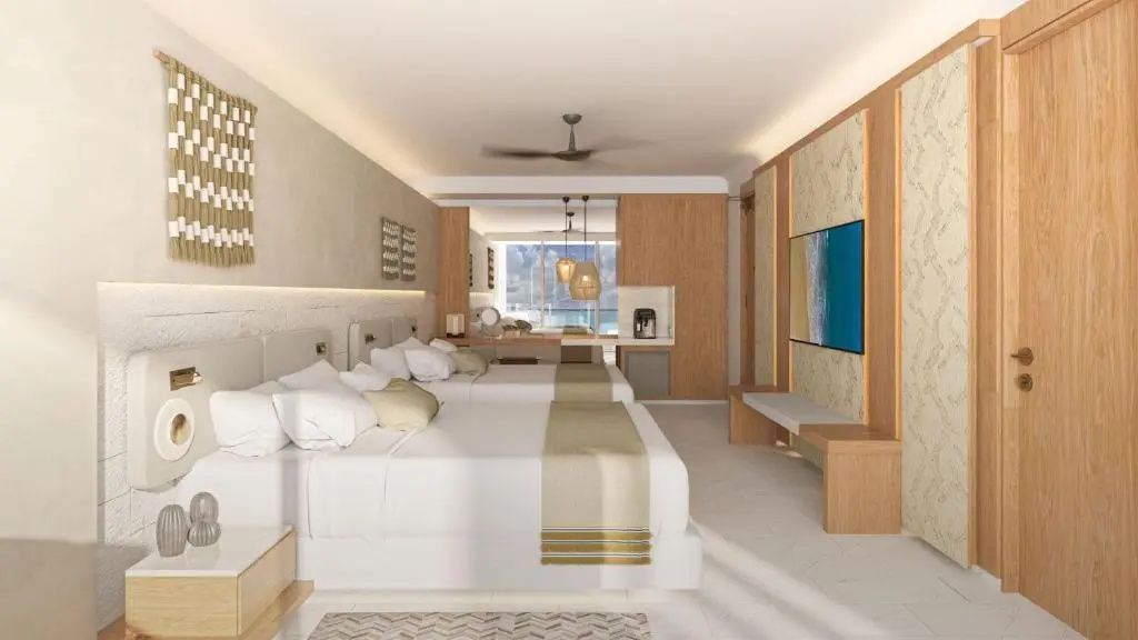 Großzügiges Zimmer mit zwei Doppelbetten, Fernseher an der Wand und Holzmöbeln.