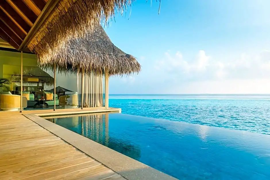 Privater Infinity-Pool einer Overwater-Villa mit Blick auf das offene Meer.