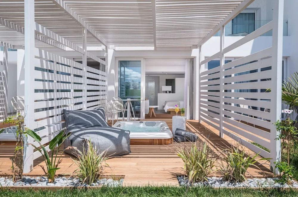 Terrasse mit Holzfußboden, Sitzsack, kleinem Whirlpool und hölzernem Sonnenschutz.