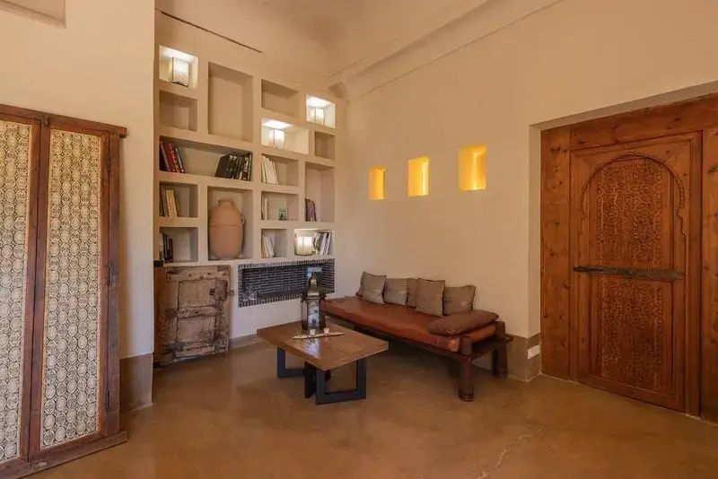 Sitzecke in einer Lounge mit Holzbank, Couchtisch und Wandregalen.