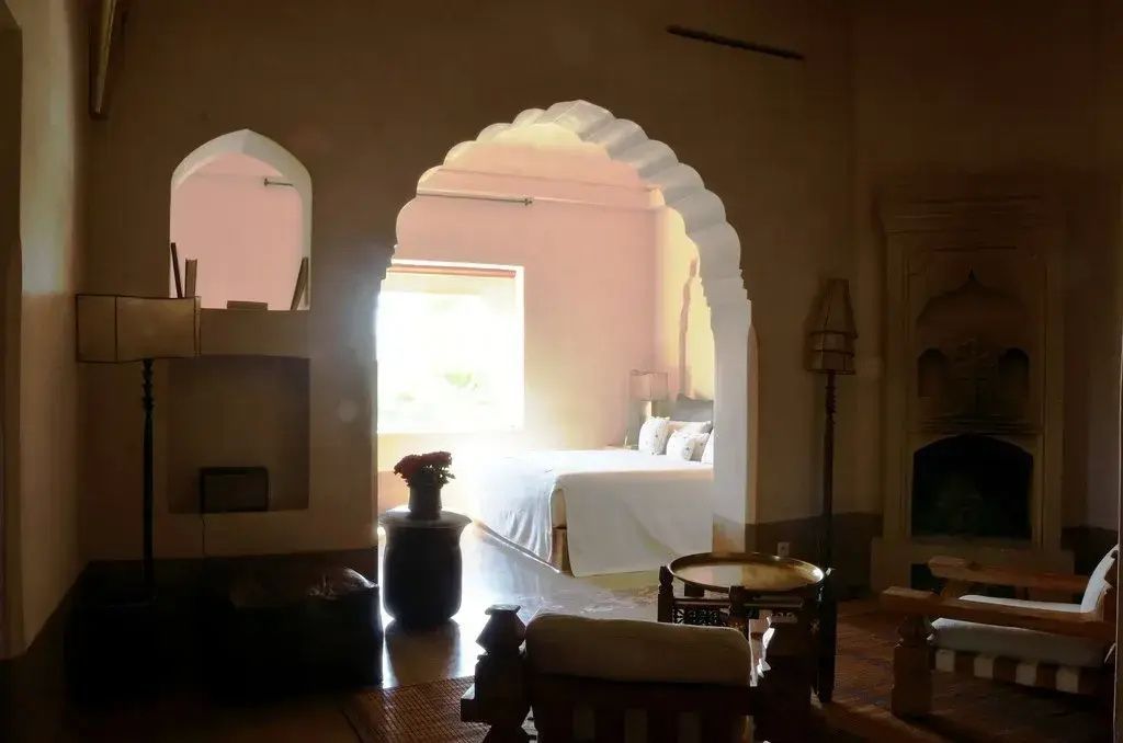 Blick durch einen orientalischen Torbogen auf das helle Schlafzimmer.