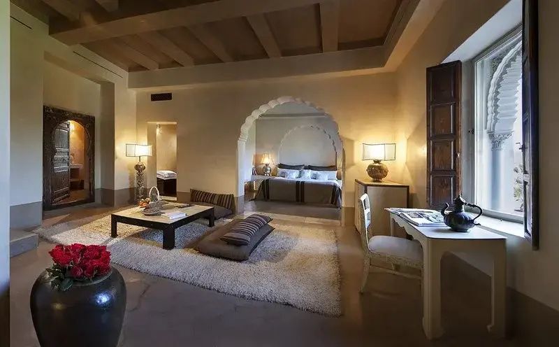 Wohnbereich der Suite mit einem Bogen zum angrenzenden Schlafbereich mit Doppelbett.