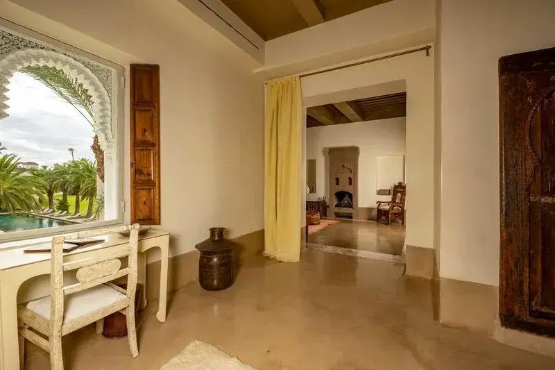 Eingangsbereich einer Suite mit gelbem Vorhang und Durchgang zum Raum mit Kamin.
