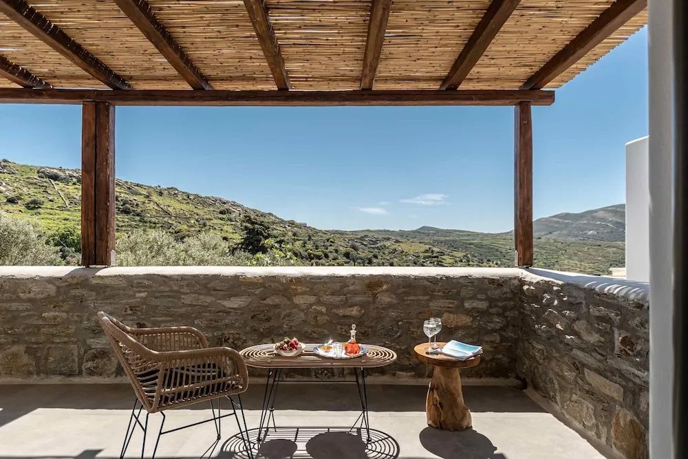Schattige Terrasse mit Sitzgelegenheiten und Blick auf die umliegende Landschaft.