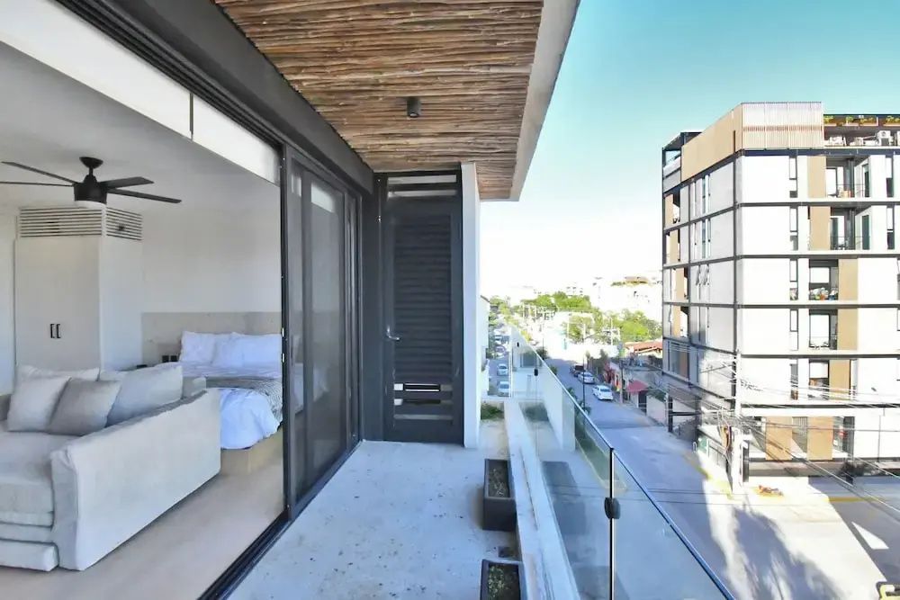 Balkon einer Suite mit Glasgeländer und Blick auf die angrenzende Stadtstraße.