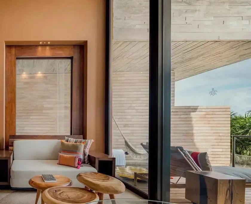 Sitzecke im Zimmer mit direktem Blick auf den Balkon und eine Hängematte