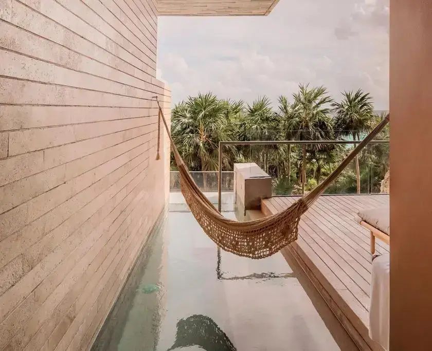 Balkon mit kleinem Pool, Hängematte und Ausblick auf tropische Palmen