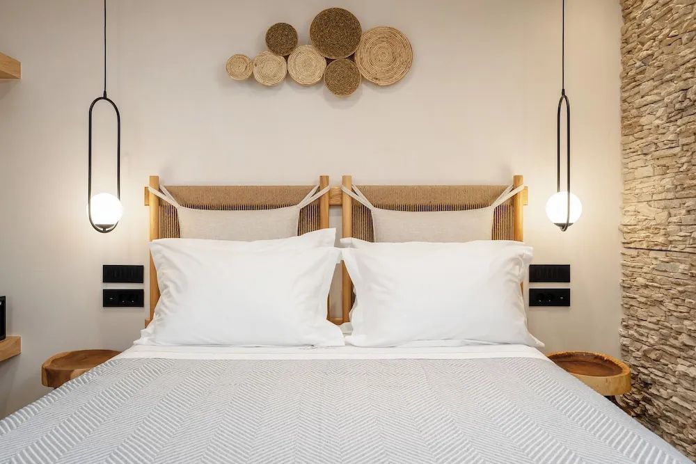 Symmetrisch ausgerichtetes Doppelbett mit hellen Kissen und Wanddekoration.