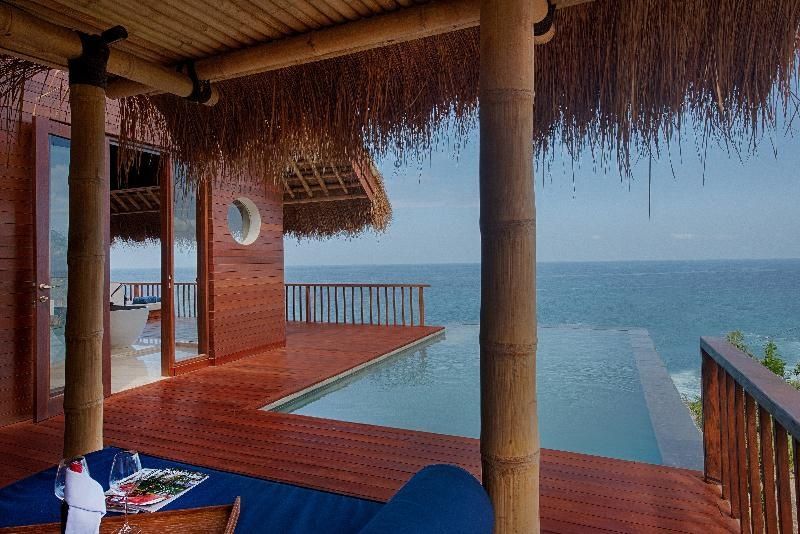Sonnendeck aus Holz mit einem Infinity-Pool und weiter Sicht über den Ozean.