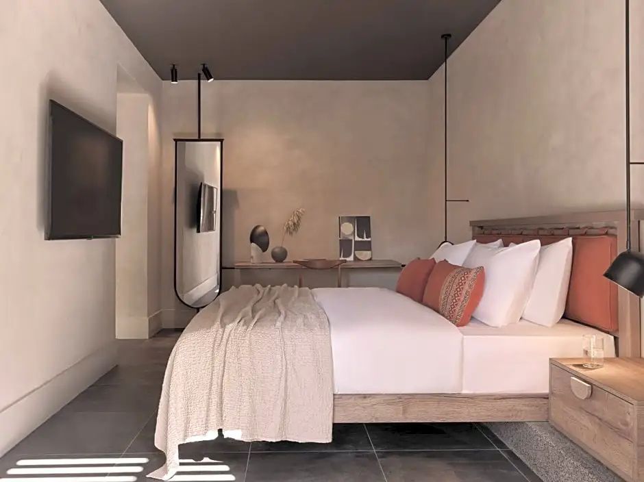 Modernes Schlafzimmer mit Holzdoppelbett, Spiegel, Wandfernseher und Schreibtisch.