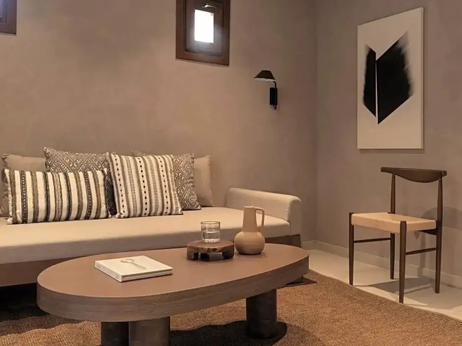 Wohnbereich eines Zimmers mit Sofa, hölzernem Couchtisch und modernem Wandbild.