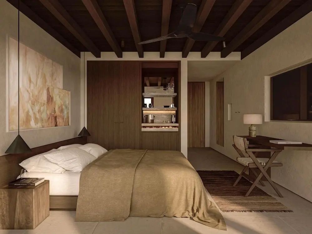 Schlafzimmer mit Holzdecke, großem Doppelbett, Holzschrank und Schreibtisch.