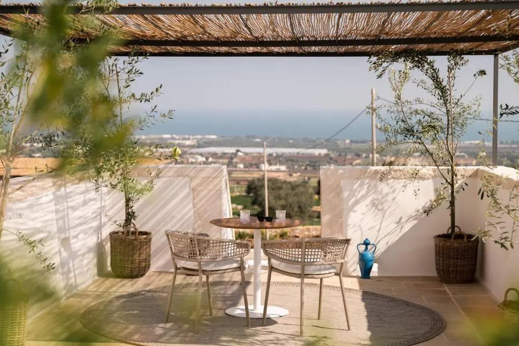 Sitzplatz auf einer Terrasse mit Tisch, Stühlen und Blick auf das Meer