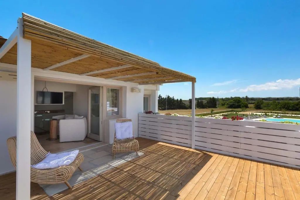 Holzterrasse mit Bambusüberdachung, Sitzgelegenheiten und Blick auf die Landschaft.