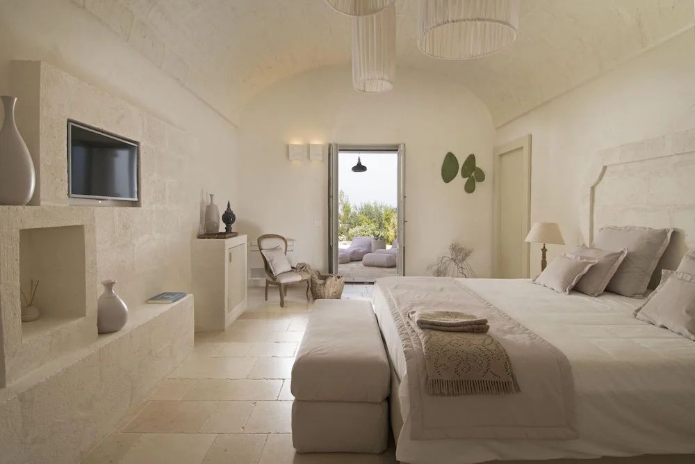 Geräumiges Schlafzimmer mit Tonnengewölbe und Blick auf die Terrasse.